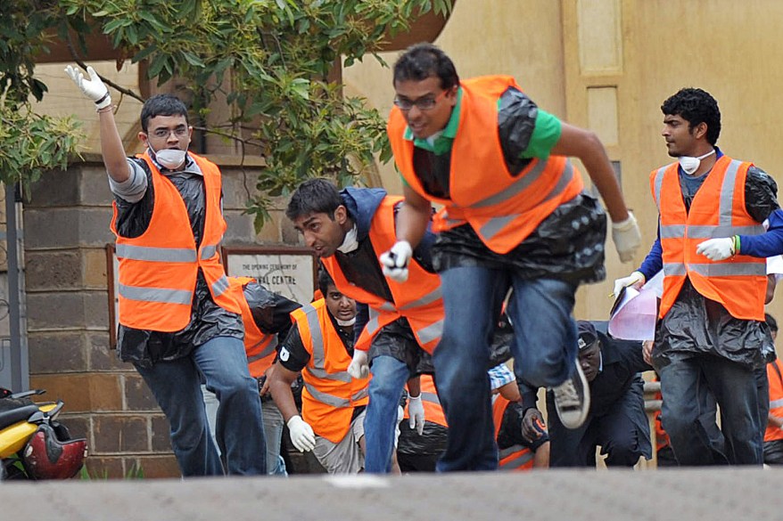 Volunteers run for cover after hearing a volley of gunshots.