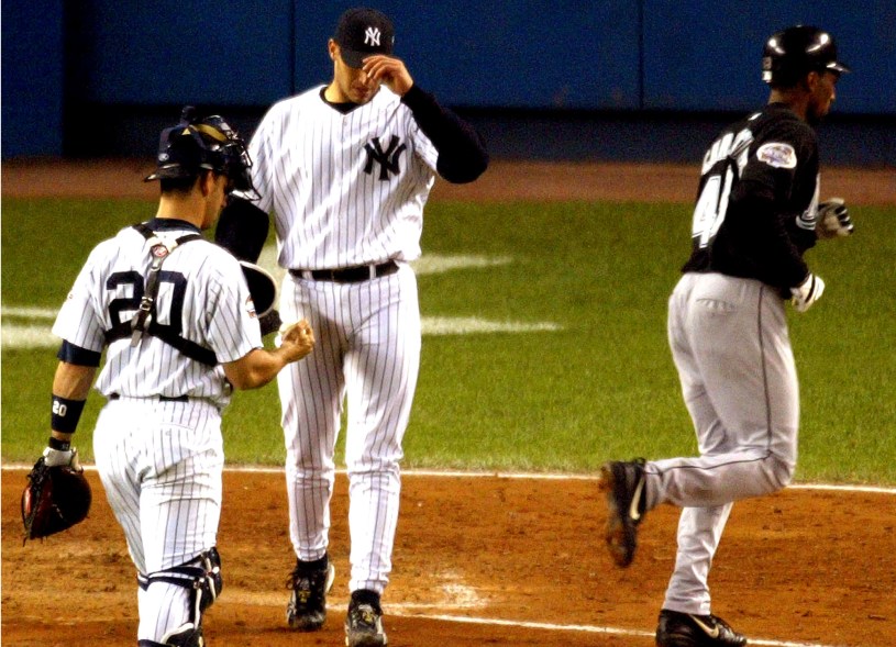 Yankees pitcher Andy Pettitte walks back to the mound past Jorge Posada as Marlins Juan Encarnacion walks to the dugout after hitting an RBI sac fly in the sixth inning of World Series Game 6 against the Marlins at Yankee Stadium in New York, Oct. 25, 2003. (Photo by Jeff Zelevansky)