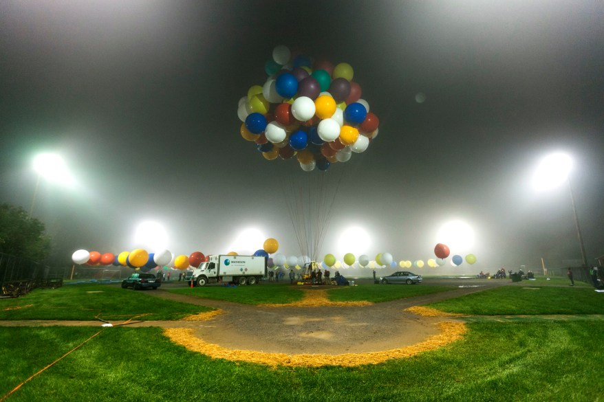 Jonathan Trappe is surrounded by balloons that will he will use to float across the Atlantic Ocean from Caribou, Maine.