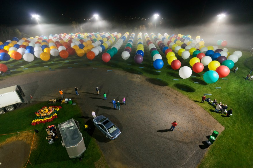 Jonathan Trappe is surrounded by balloons that will he will use to float across the Atlantic Ocean from Caribou, Maine.