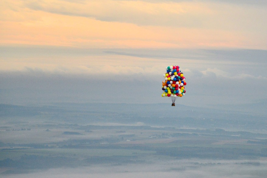 Jonathan Trappe is surrounded by balloons that will he will use to float across the Atlantic Ocean from Caribou, Maine.