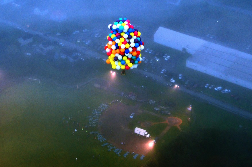 Jonathan Trappe is surrounded by balloons that will he will use to float across the Atlantic Ocean from Caribou, Maine.