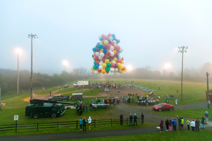 Jonathan Trappe is surrounded by balloons that will he will use to float across the Atlantic Ocean from Caribou, Maine.