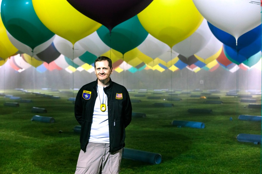 Jonathan Trappe is surrounded by balloons that will he will use to float across the Atlantic Ocean from Caribou, Maine.