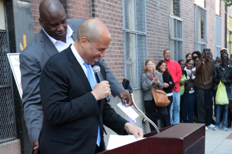 Shaquille O'Neal gives Newark mayor Cory Booker a playful slap on the butt.