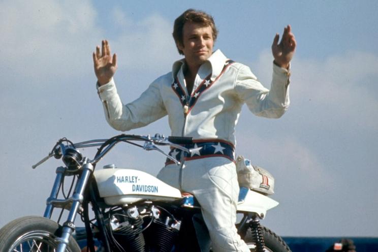 Motorcycle daredevil Evel Knievel poised on his Harley-Davidson.