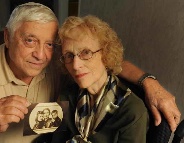 Irene Hizme and brother Rene, survivors of Josef Mengele’s twisted experiments on twins, show a photo of them with their mom.