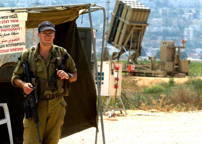 An Israeli soldier guards an air force Iron Dome missile intercepter unit stationed on the outskirts of Haifa, Israel