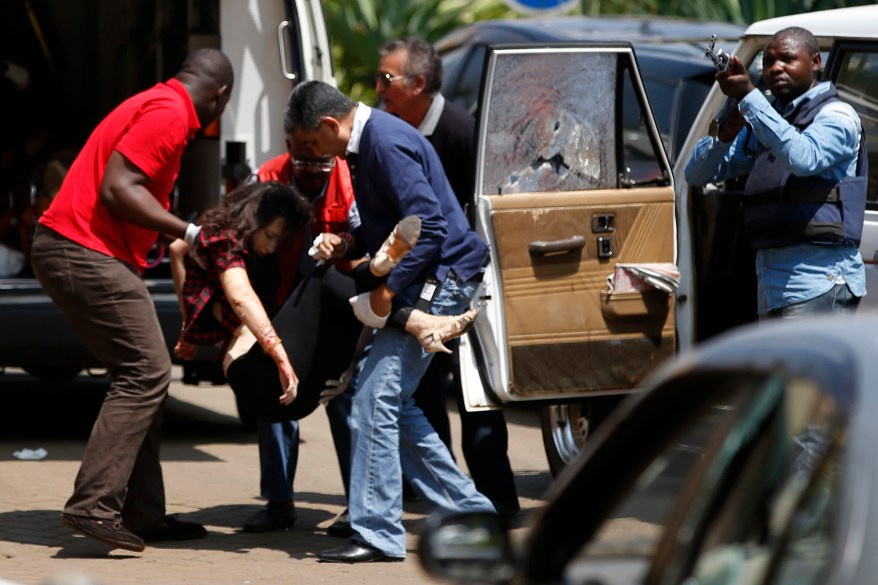 Emergency services carry a woman to an ambulance in the car park in Nairobi