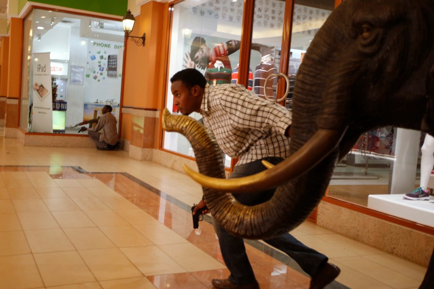 Armed police search through a shopping centre for a gunman in Nairobi