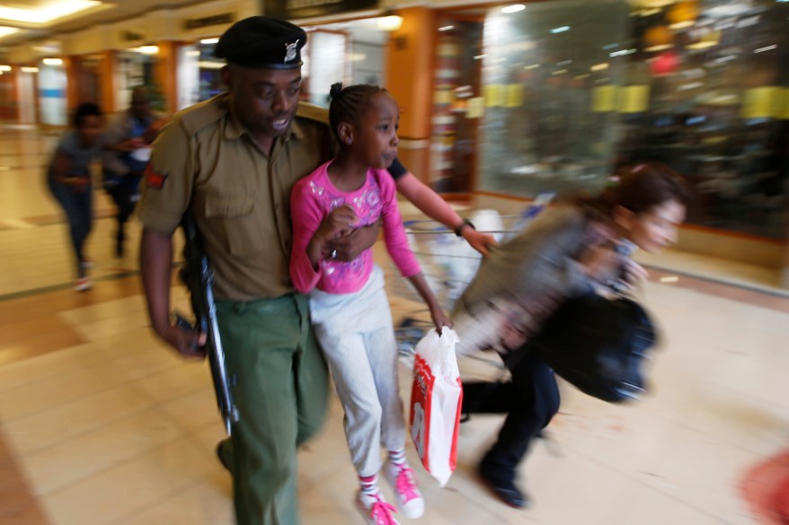 A soldier carries a child to safety as armed police hunt gunmen who went on a shooting spree at Westgate shopping centre in Nairobi