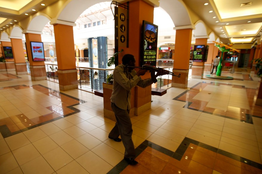 An armed police searches through a shopping centre for gunmen in Nairobi