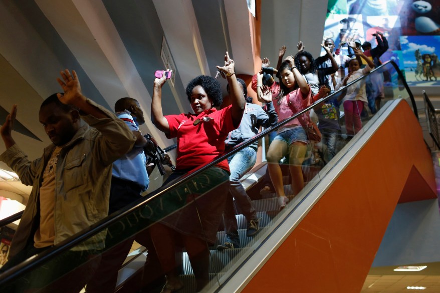 Civilians escape an area at the Westgate Shopping Centre in Nairobi