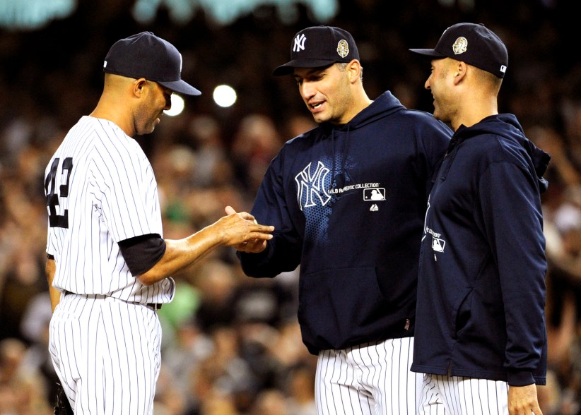 Mariano Rivera shakes hands with Andy Pettitte after the lefty, along with Derek Jeter, came to remove him from the game.