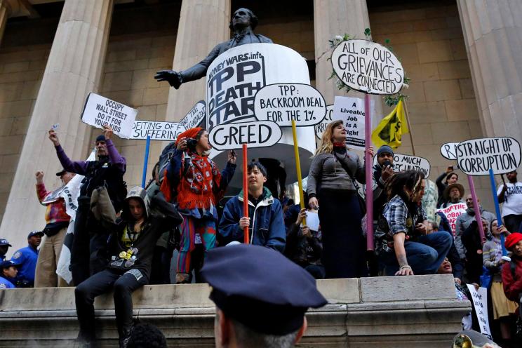 Occupy Wall Street protesters stand on the steps of Federal Hall, across the street from the New York Stock Exchange in New York September 17, 2013