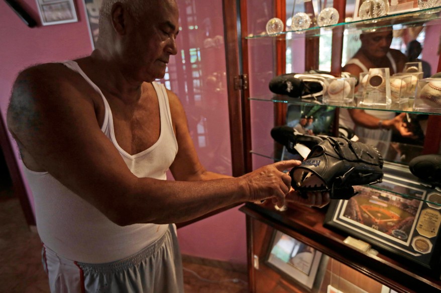 Mariano Rivera Palacios, father of New York Yankee pitcher Mariano Rivera, shows his son's baseball glove at his home where he has a wall filled with memorabilia from his son in Puerto Caimito, Panama. Rivera Palacios, who worked as a captain on a sardine boat, likes to muse about his son's long journey to New York: "Sometimes when I'm in Yankee Stadium, I'm watching from the stands and I say to myself: `Look where Mariano has come from _ from Puerto Caimito, a town full of mud and a stinking fish meal plant. But this is what feeds us.''