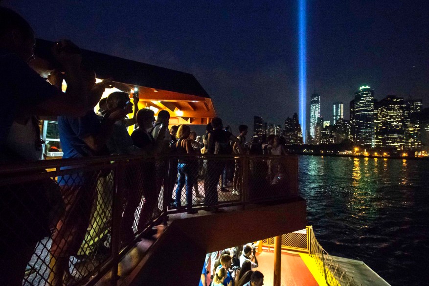 Commuters look out at the Tribute in Light from the Staten Island Ferry as it illuminates the sky over Lower Manhattan on the 12-year anniversary of the 9/11 attacks in New York