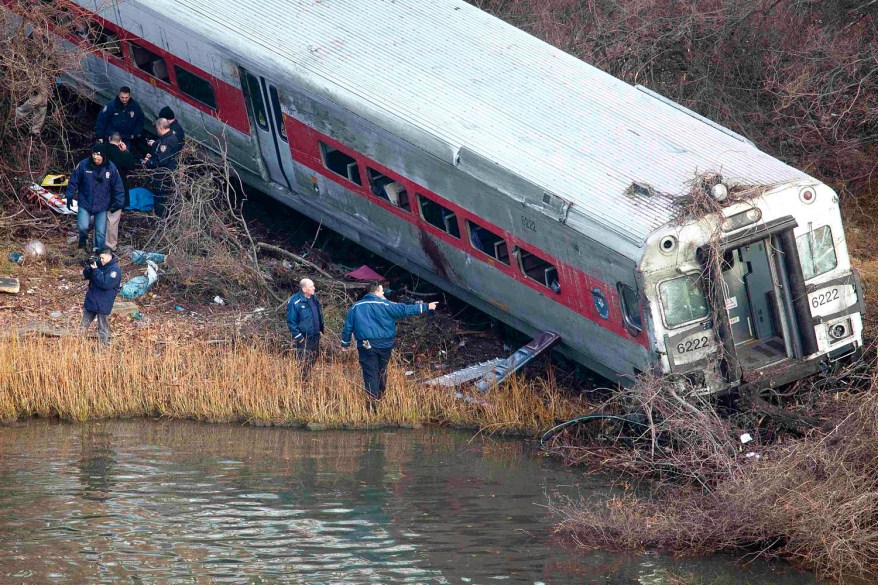 A Metro-North passenger train derailed on a curved section of track in the Bronx on Sunday morning, killing four people and injuring 63 as it came to rest just inches from the water, authorities said.