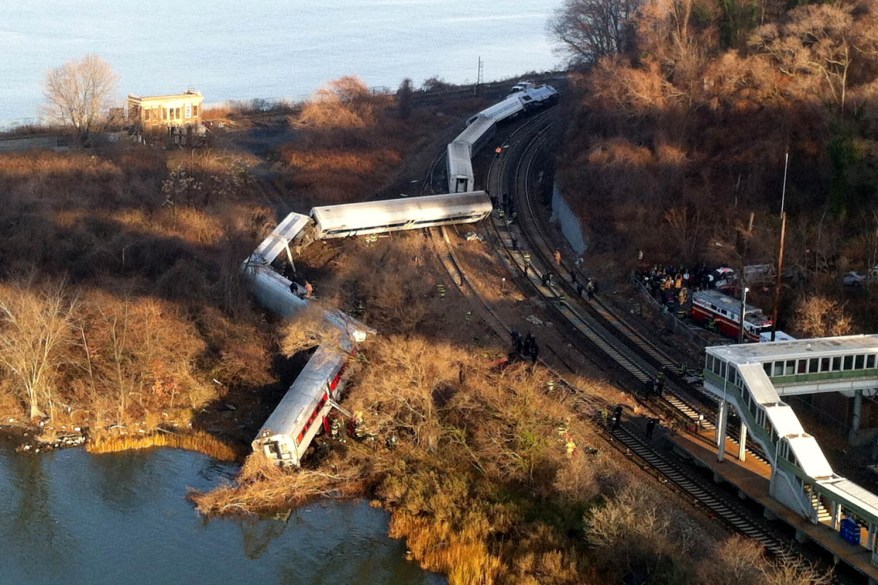 A Metro-North passenger train derailed on a curved section of track in the Bronx on Sunday morning, killing four people and injuring 63 as it came to rest just inches from the water, authorities said.