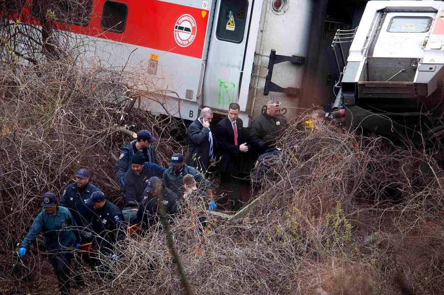 fficials remove a body from the scene of a Metro-North train derailment in the Bronx.