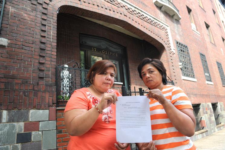 Long term residents Jojo Monsanto (left) and Juliet Abucejo hold a copy of their tenancy termination letter outside St. Joseph's Residence.