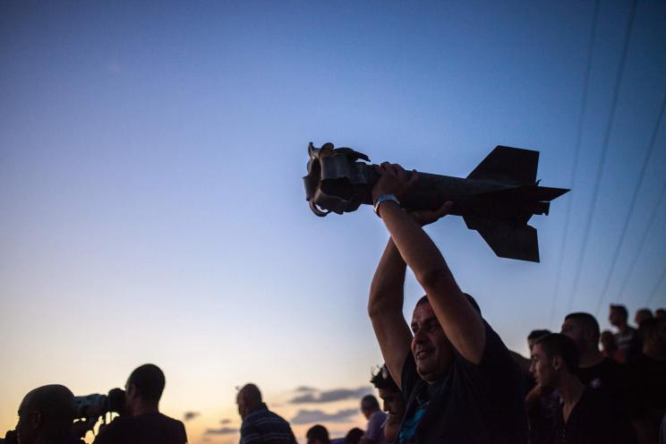 An Israeli man holds the remains of a Quassam rocket that was supposedly shot down by Israel's "Iron Dome" on July 13.