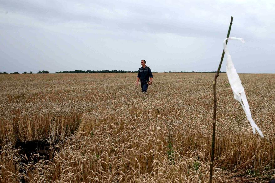 A member of the Ukrainian Emergency Ministry walks past a white flag marking the location of a body