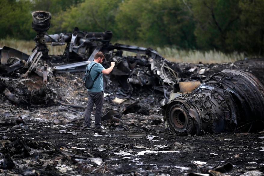 A journalist takes photographs at the crash site.