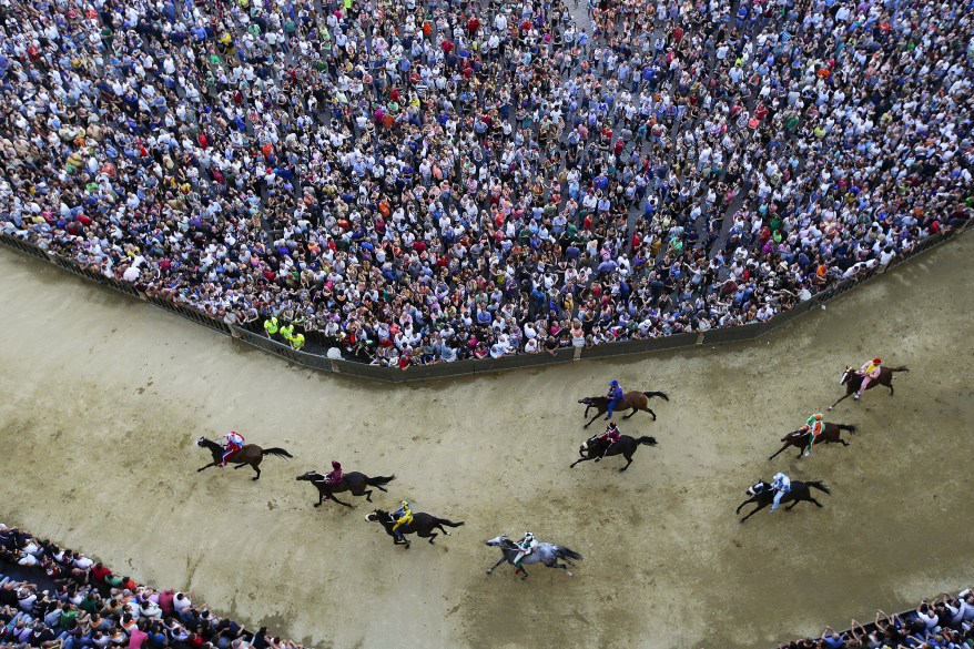 Crowds watch thethe Palio di Siena, Italy, horse race.