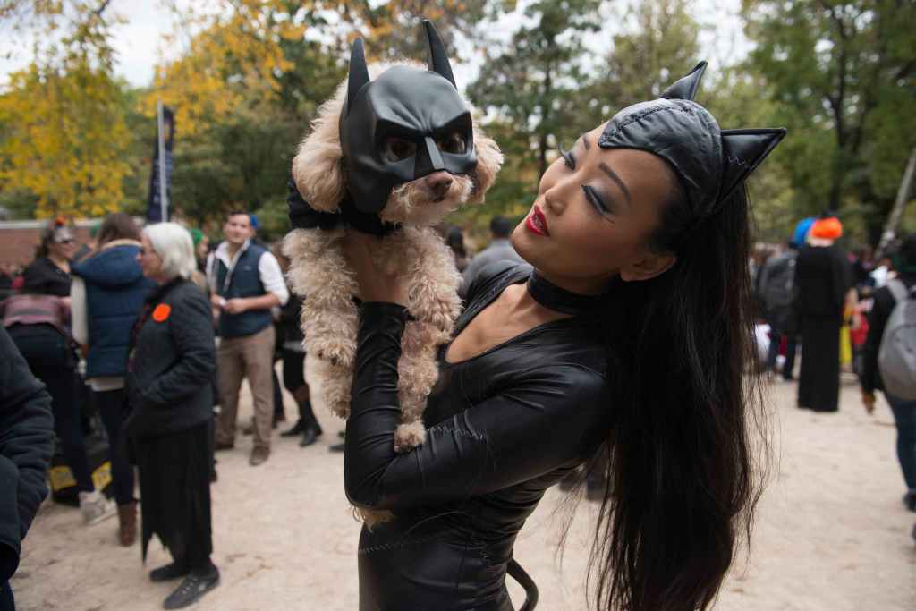 A woman dressed as Catwoman holds her dog dressed as Batman during the annual Tompkins Square Halloween Dog Parade in the Manhattan borough of New York City, October 24, 2015. REUTERS/Stephanie Keith