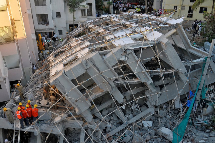 Police and rescue workers look for survivors in the rubble at the site of a collapsed under construction building in Bengaluru, India.