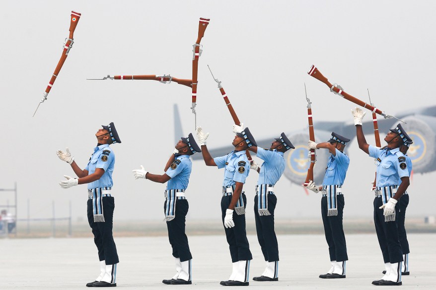 Indian Air Force soldiers toss their rifles as they perform during the full-dress rehearsal for Indian Air Force Day at the Hindon air force station on the outskirts of New Delhi, India,.