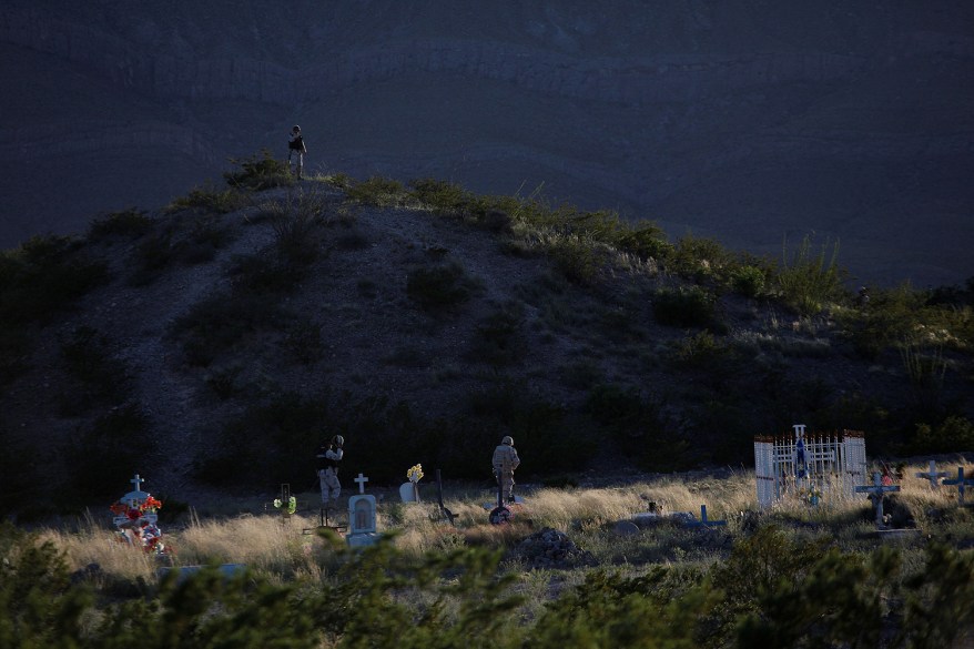 Soldiers patrol on foot at a cemetery after a gunfight with unknown assailants at Juarez Valley, Mexico.