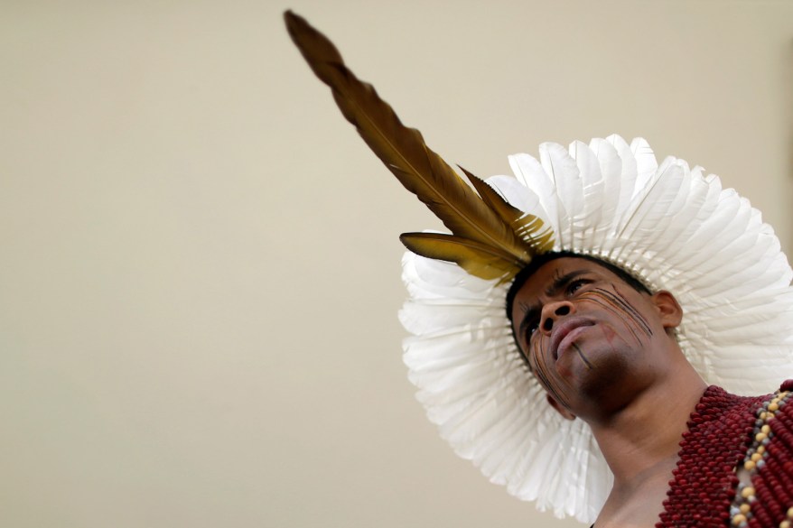 An indigenous man from the Pataxo tribe occupies the entrance of the Planalto Palace during a protest of indigenous people from various tribes against agribusinesses and in demand of the demarcation of their ancestral lands, in Brasilia, Brazil.