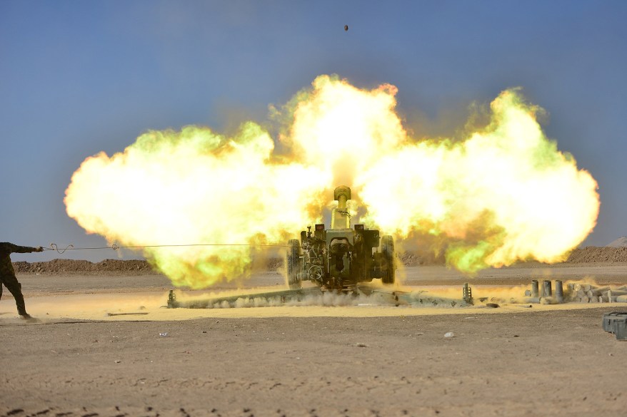 Shi'ite fighters fire artillery towards Islamic State militants during a battle with Islamic State militants on the outskirt of Tal Afar west of Mosul, Iraq.