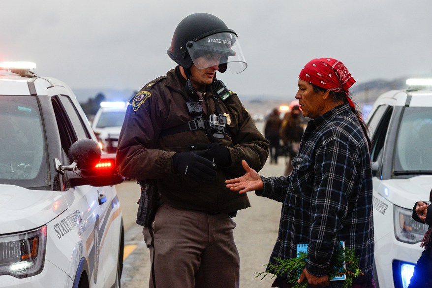 A protester shakes the hand of a police officer while other protesters block highway 1806 at a Dakota Access Pipeline demonstration near the Standing Rock Indian Reservation, North Dakota.