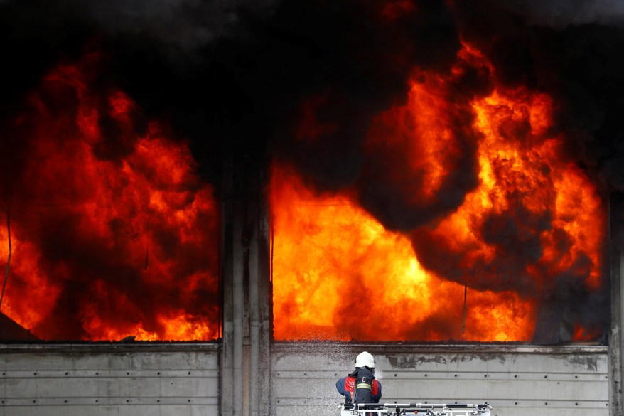 A fireman tries to extinguish a fully developed fire at a plastic factory in Istanbul, Turkey.