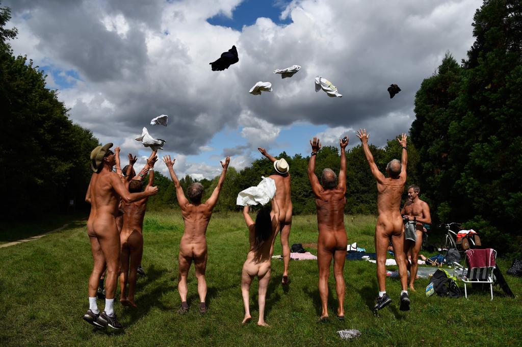 EDITORS NOTE: Graphic content / Naked people throw their clothes up in the air at a newly opened space for naturists at the Bois de Vincennes park in Paris on August 31, 2017. The space will be open daily until October 15th. / AFP PHOTO / Bertrand GUAYBERTRAND GUAY/AFP/Getty Images