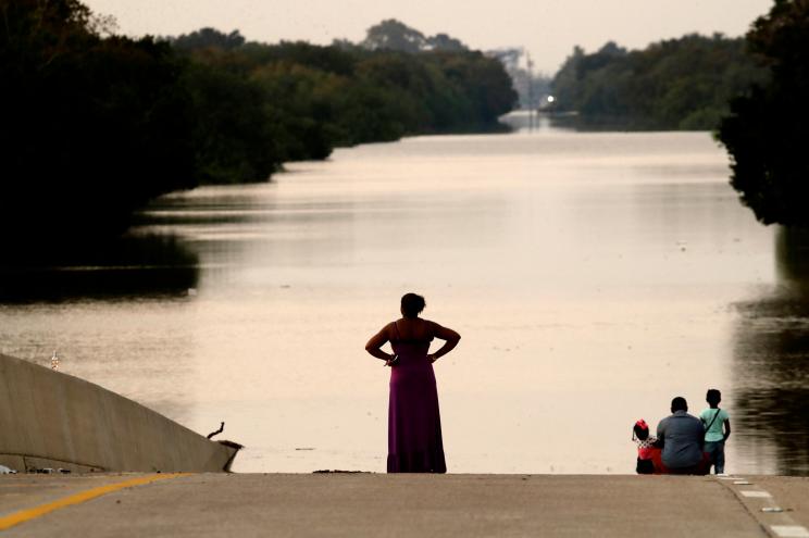 Jessica Anderson, with her husband Darrell and daughters Lauren, and Harper look at floodwaters in Addicks Reservoir from a closed freeway in the aftermath of Hurricane Harvey on Sept. 1.