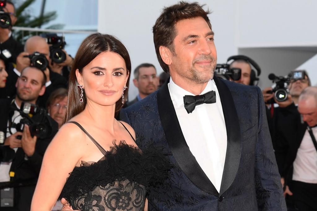 Penelope Cruz in a black dress with Javier Bardem in a tuxedo.