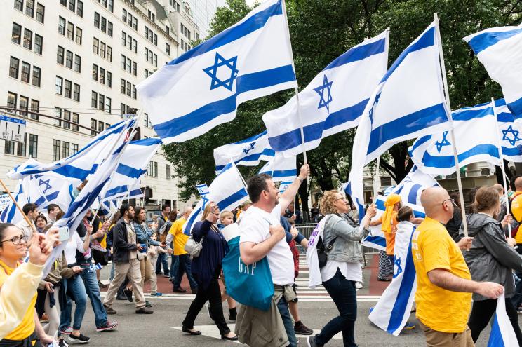 Participants seen carrying the Israeli flags during the parade.