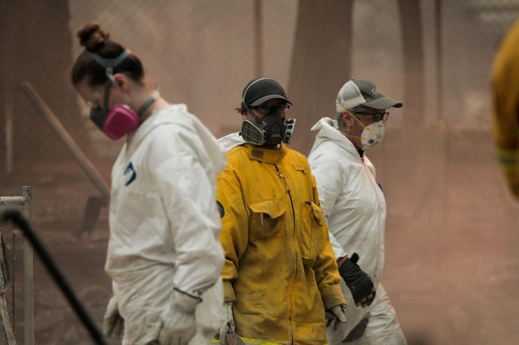 Archaeologists wear masks to find victims of the Camp Fire in Paradise, California.