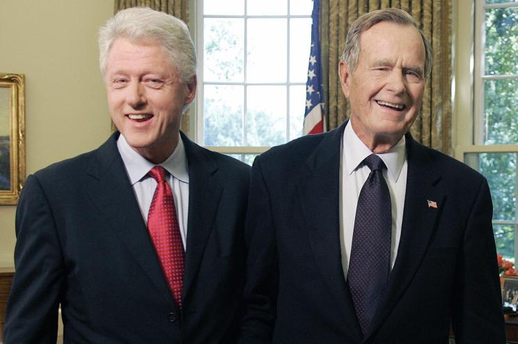 Bill Clinton and George H.W. Bush standing in the Oval Office in 2005.