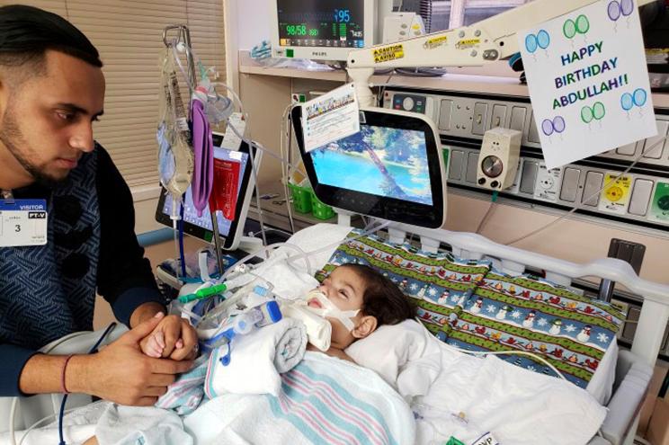 Ali Hassan with his 2-year-old son Abdullah in a Sacramento hospital in early December.