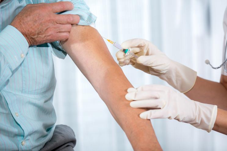 Nurse giving man a vaccination.