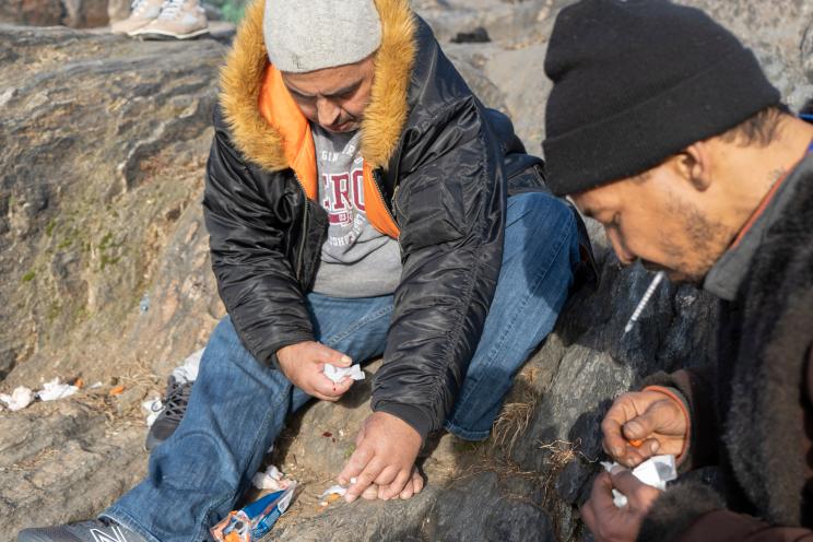 A man shoots up heroin and has needles strewn about him in St. Mary's Park in the Bronx.