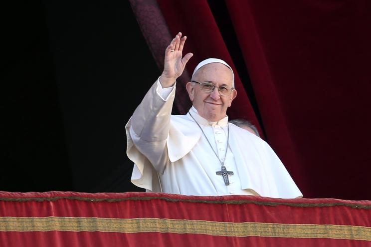 Pope Francis waves to the faithful as he delivers his Christmas 'Urbi et Orbi' blessing message from the central balcony of St Peter's Basilica.