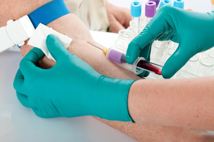 Doctor drawing blood from a patient's arm