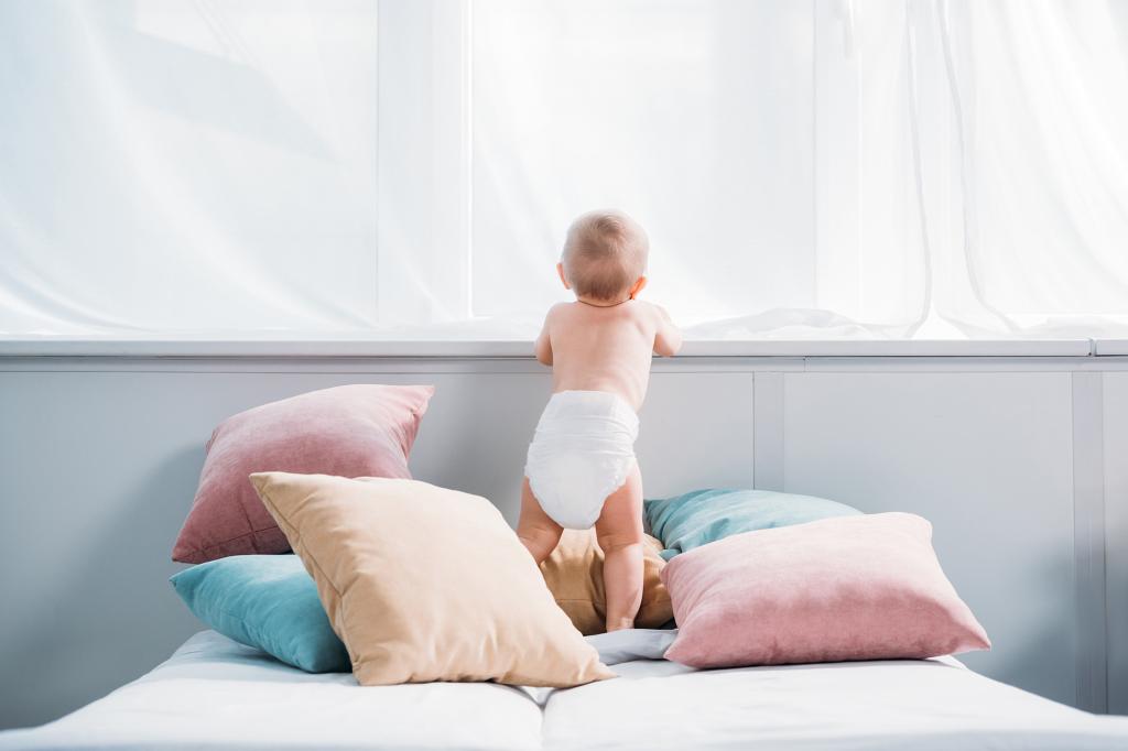 Baby leaning against a ledge.