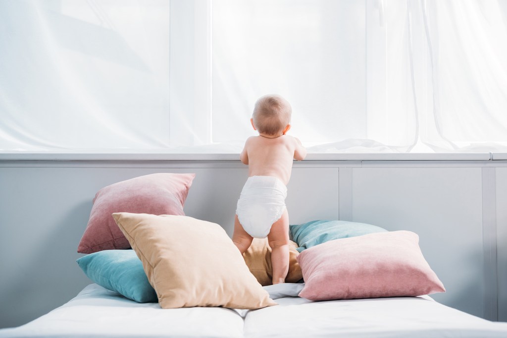 Baby leaning against a ledge. 